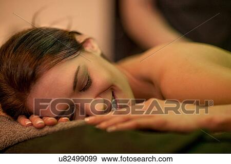 Stock Photo - Close up of mid adult woman lying on massage table. Fotosearch