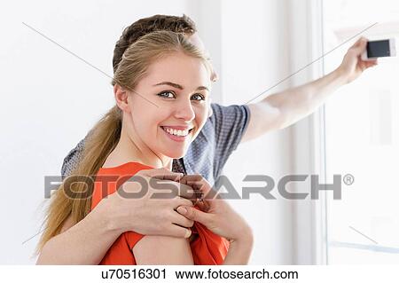 Close up of young couple taking photograph from window View Large Photo Image Stock Image - Close up of young couple taking photograph from window. Fotosearch