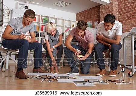 Colleagues in meeting looking at papers on floor View Large Photo Image Stock Photography - Colleagues in meeting looking at papers on floor. Fotosearch