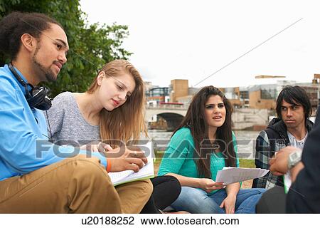 College students sitting outdoors with papers View Large Photo Image Stock Image - College students sitting outdoors with papers. Fotosearch