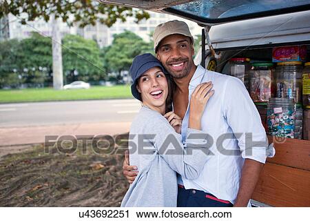Stock Image - Couple by campervan with candy jars. Fotosearch