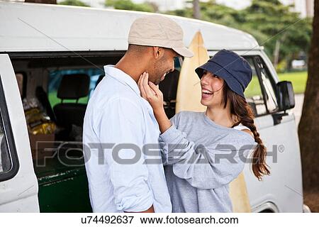 Couple by campervan, woman touching man's face View Large Photo Image Stock Photo - Couple by campervan, woman touching man's face. Fotosearch