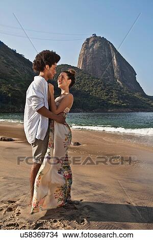 Picture - Couple hugging on beach, Rio de Janeiro, Brazil. Fotosearch