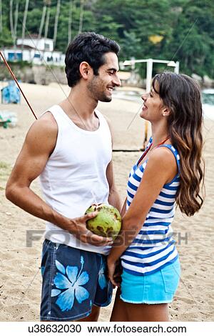 Couple on beach with coconut drink View Large Photo Image Stock Image - Couple on beach with coconut drink. Fotosearch