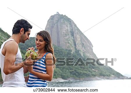 Picture - Couple on beach with Sugarloaf Mountain, Rio de Janeiro, Brazil. Fotosearch