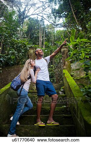Couple on steps in jungle, man pointing View Large Photo Image Stock Image - Couple on steps in jungle, man pointing. Fotosearch