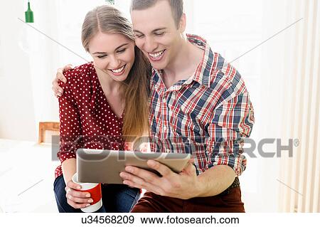 Couple on video chat using digital tablet View Large Photo Image Stock Photo - Couple on video chat using digital tablet. Fotosearch