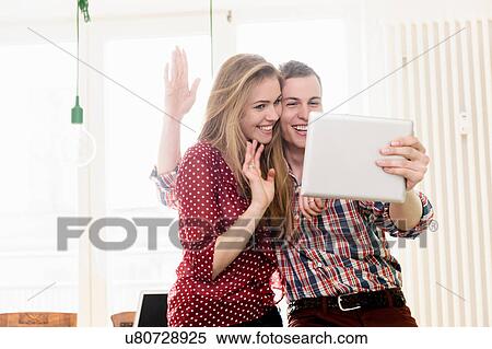 Stock Photography - Couple on video chat using digital tablet. Fotosearch