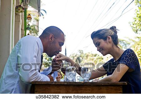 Couple outdoors at cafe, man kissing hand of girlfriend View Large Photo Image Stock Image - Couple outdoors at cafe, man kissing hand of girlfriend. Fotosearch