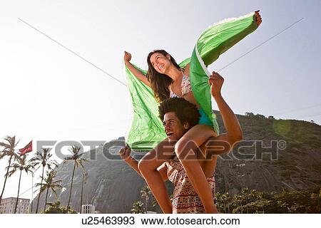 Couple with flag, woman on man's shoulders View Large Photo Image Stock Image - Couple with flag, woman on man's shoulders. Fotosearch