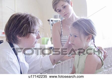 Stock Photography - Doctor examining girl, mother watching. Fotosearch