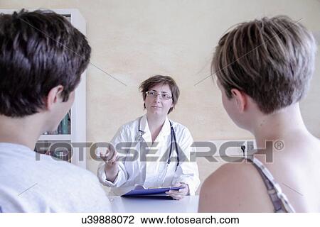 Doctor talking to young couple View Large Photo Image Stock Image - Doctor talking to young couple. Fotosearch