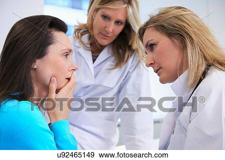 Stock Photo - Doctors comforting female patient. Fotosearch