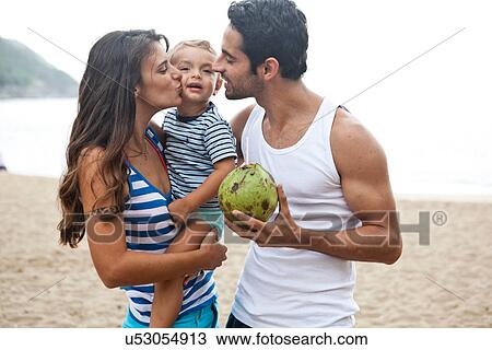 Family on beach, mother kissing son on cheek View Large Photo Image Stock Image - Family on beach, mother kissing son on cheek. Fotosearch