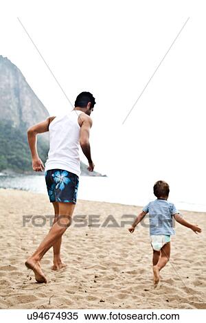 Stock Photography - Father and son playing on beach. Fotosearch
