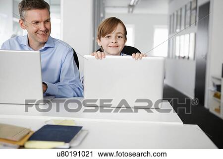 Stock Image - Father and son using laptops. Fotosearch