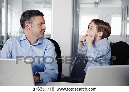 Father using laptop, son pulling faces View Large Photo Image Stock Photo - Father using laptop, son pulling faces. Fotosearch