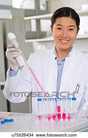Female scientist pipetting liquid for reaction mixture View Large Photo Image Picture - Female scientist pipetting liquid for reaction mixture. Fotosearch