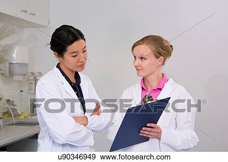 Female scientists with clipboard in laboratory View Large Photo Image Stock Photo - Female scientists with clipboard in laboratory. Fotosearch