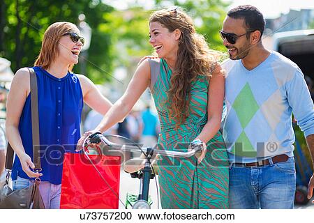 Friends laughing, women pushing bicycle View Large Photo Image Stock Image - Friends laughing, women pushing bicycle. Fotosearch