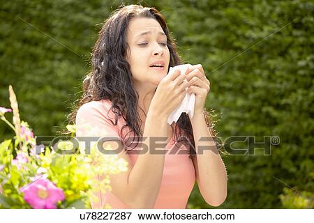 Stock Photo - Girl about to sneeze into tissue. Fotosearch