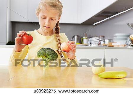 Girl balancing apples on broccoli scales View Large Photo Image Stock Photography - Girl balancing apples on broccoli scales. Fotosearch