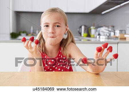 Girl eating raspberries from fingers View Large Photo Image Stock Photo - Girl eating raspberries from fingers. Fotosearch