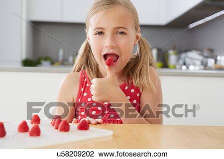 Girl eating raspberries from thumb View Large Photo Image Stock Image - Girl eating raspberries from thumb. Fotosearch