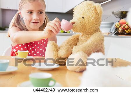 Girl having tea party with soft toys View Large Photo Image Stock Photo - Girl having tea party with soft toys. Fotosearch