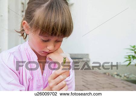 Girl holding dandelion clock looking sad View Large Photo Image Stock Image - Girl holding dandelion clock looking sad. Fotosearch