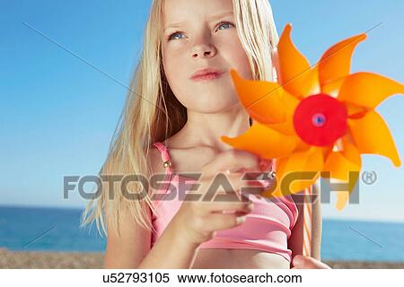 Girl holding toy windmill View Large Photo Image Stock Photography - Girl holding toy windmill. Fotosearch