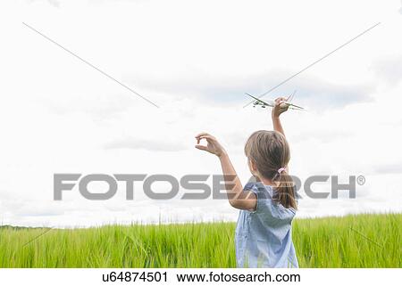 Girl in field with toy aeroplane View Large Photo Image Stock Image - Girl in field with toy aeroplane. Fotosearch