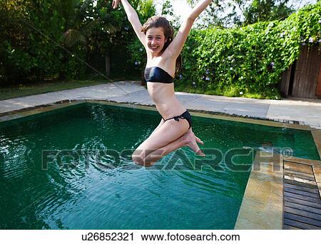 Girl jumping into swimming pool View Large Photo Image Stock Image - Girl jumping into swimming pool. Fotosearch