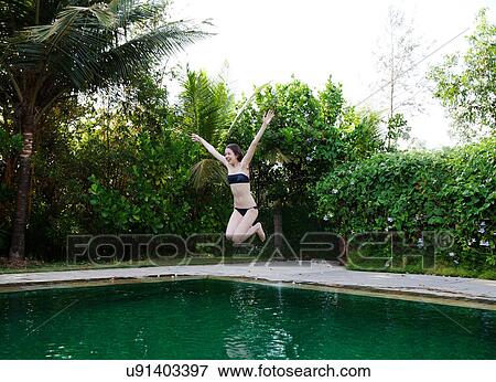Girl jumping into swimming pool View Large Photo Image Stock Photo - Girl jumping into swimming pool. Fotosearch