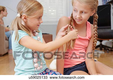 Girl plaiting sister's hair View Large Photo Image Stock Image - Girl plaiting sister's hair. Fotosearch