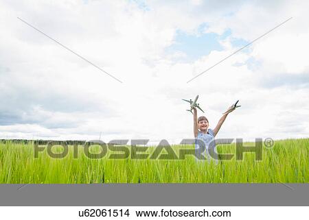 Girl playing with toy planes in field View Large Photo Image Picture - Girl playing with toy planes in field. Fotosearch