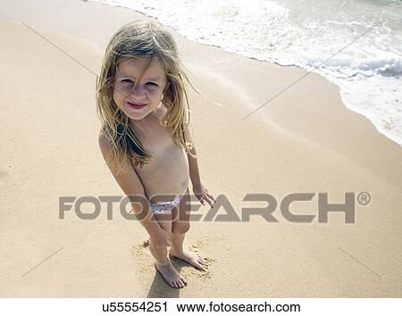 Stock Image - Girl posing for camera on beach. Fotosearch