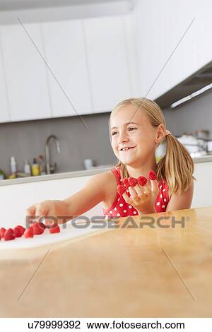 Girl putting raspberries on fingers View Large Photo Image Stock Image - Girl putting raspberries on fingers. Fotosearch