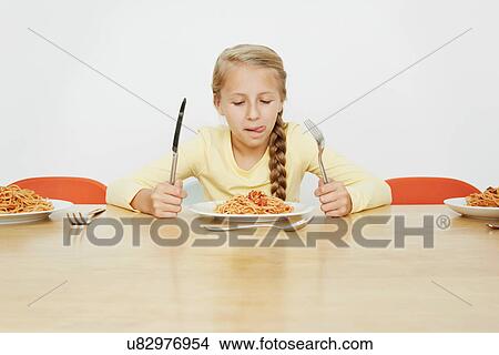 Girl sitting at table with plate full of spaghetti View Large Photo Image Picture - Girl sitting at table with plate full of spaghetti. Fotosearch