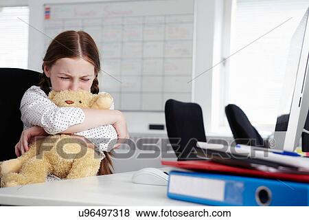 Girl sitting in office hugging teddy bear and crying View Large Photo Image Stock Photo - Girl sitting in office hugging teddy bear and crying. Fotosearch