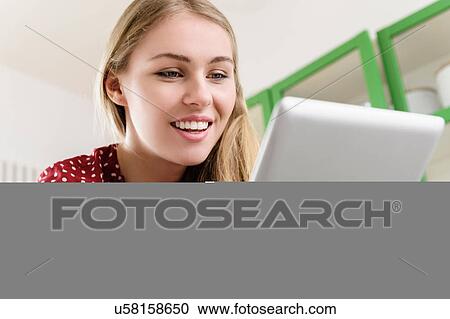 Girl smiling at digital tablet View Large Photo Image Stock Image - Girl smiling at digital tablet. Fotosearch