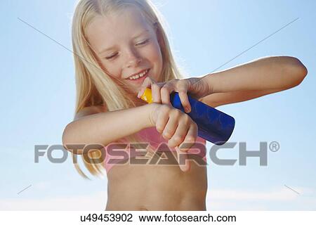 Girl spraying sunblock on hand View Large Photo Image Stock Image - Girl spraying sunblock on hand. Fotosearch