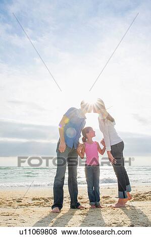 Girl standing between kissing parents View Large Photo Image Stock Photo - Girl standing between kissing parents. Fotosearch