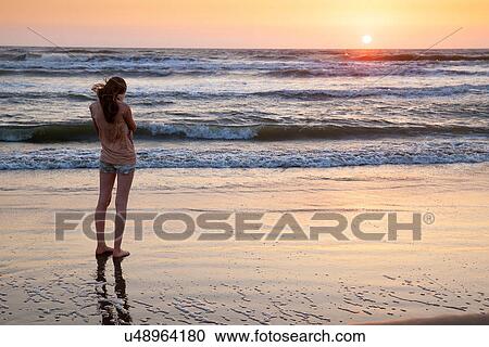 Girl standing on beach View Large Photo Image Stock Image - Girl standing on beach. Fotosearch