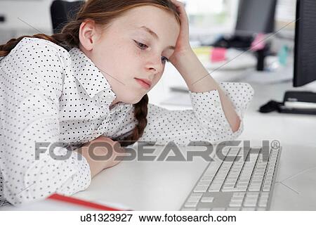 Girl staring at computer keyboard View Large Photo Image Stock Photo - Girl staring at computer keyboard. Fotosearch