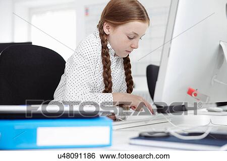 Stock Photograph - Girl using computer in office. Fotosearch