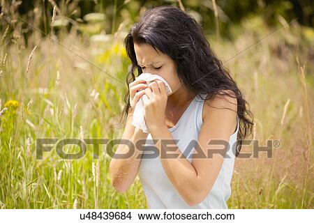Picture - Girl wiping nose with tissue. Fotosearch