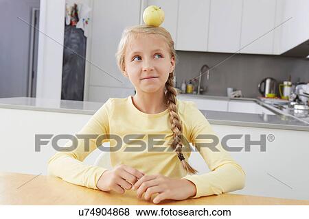 Stock Photo - Girl with apple balanced on her head. Fotosearch