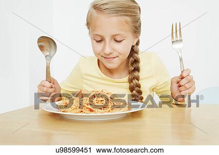 Girl with plate of spaghetti and oversized cutlery View Large Photo Image Stock Image - Girl with plate of spaghetti and oversized cutlery. Fotosearch