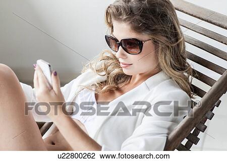 Glamorous young woman with smartphone View Large Photo Image Stock Image - Glamorous young woman with smartphone. Fotosearch